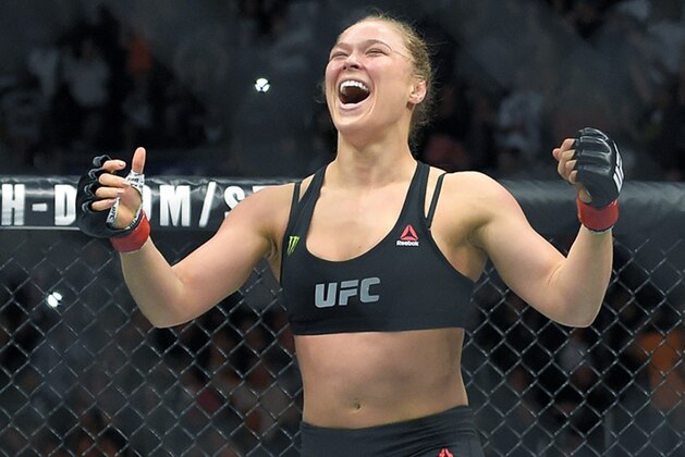 FILE - In this Feb. 28, 2015 file photo, Ronda Rousey, with Reebok insignia on her uniform, celebrates after defeating Cat Zingano in a UFC 184 mixed martial arts bantamweight title bout in Los Angeles. UFC fighters will be paid for wearing Reebok gear based on their tenure in the octagon under the mixed martial arts promotion’s new sponsorship deal. The UFC on Wednesday, May 6, 2015, announced the change in its pay structure for its deal with Reebok, which signed on late last year to outfit every fighter. (AP Photo/Mark J. Terrill, File)