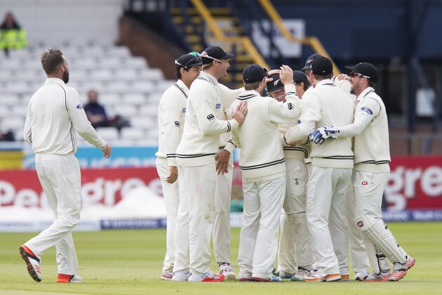New Zealand's Tom Latham, centre of group and wearing a helmet, is congratulated by teammates after catching England's Joe Root off the bowling of Mark Craig, left, on the fifth day of the second Test match between England and New Zealand at Headingley cricket ground in Leeds, England, Tuesday, June 2, 2015. (AP Photo/Jon Super)