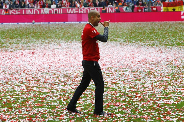 Bayern's head coach Pep Guardiola gestures to get a beer as the team celebrate winning the Bundesliga title after the German first division Bundesliga soccer match between FC Bayern Munich and FSV Mainz 05 at the Allianz Arena in Munich, Germany, Saturday, May 23, 2015. (AP Photo/Matthias Schrader)