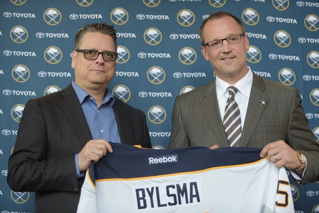Buffalo Sabres GM Tim Murray, left, and newly hired coach Dan Bylsma hold a Sabres' jersey as they pose for a photo after a news conference Thursday, May 28, 2015, in Buffalo, N.Y.  A week after losing out on Mike Babcock, the Buffalo Sabres went with another experienced Stanley Cup winner by hiring Dan Bylsma to become their next coach.  (AP Photo/Gary Wiepert)