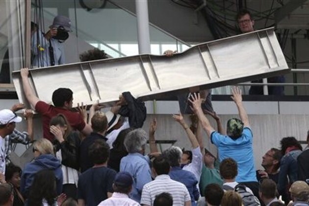 People remove a screen panel which fell on a stand of center court as France's Jo-Wilfried Tsonga plays Japan's Kei Nishikori during their quarterfinal match of the French Open tennis tournament at the Roland Garros stadium, Tuesday, June 2, 2015 in Paris, France. (AP Photo/Thibault Camus)