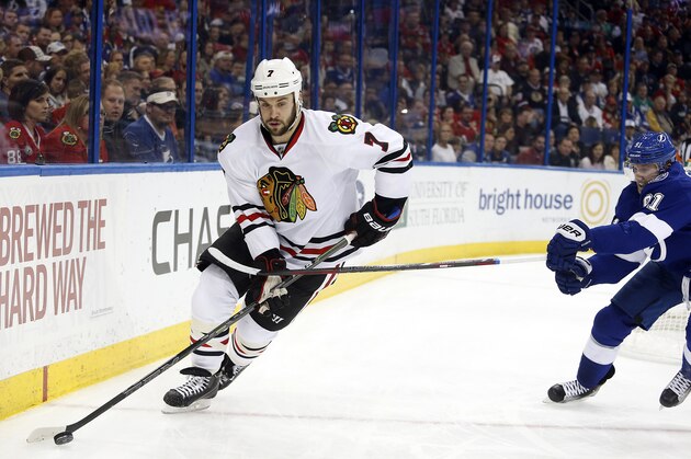 Chicago Blackhawks defenseman Brent Seabrook (7) evades Tampa Bay Lightning center Steven Stamkos (91) while controlling the puck during the second period of an NHL hockey game Friday, Feb. 27, 2015, in Tampa, Fla. (AP Photo/Brian Blanco)