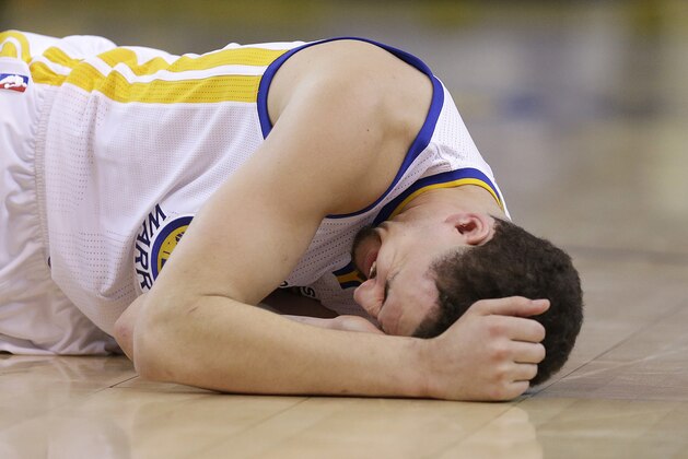 In this photo taken May 27, 2015, Golden State Warriors guard Klay Thompson reacts after taking a knee to his head from Houston Rockets forward Trevor Ariza during the second half of Game 5 of the NBA basketball Western Conference finals. The Warriors hope to get healthy and stay in tune over the next week before facing the Cleveland Cavaliers in the NBA Finals. Thompson needs to pass through the league's concussion protocol and Stepehen Curry is trying to get his aching body back at full strength.   (AP Photo/Ben Margot)
