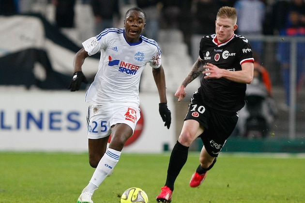 Marseille's French midfielder Giannelli Imbula, left, challenges for the ball with Reims' forward Gaetan Charbonnier,  during the League One soccer match between Marseille and Reims, at the Velodrome Stadium, in Marseille, southern France, Friday,  Feb. 13, 2015. (AP Photo/Claude Paris)