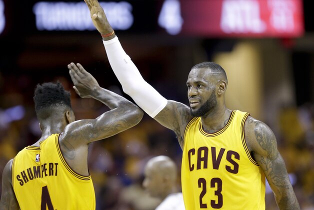 Cleveland Cavaliers forward LeBron James (23) high fives guard Iman Shumpert (4) during a timeout  in the first half of Game 4 of the NBA basketball Eastern Conference Finals against the Atlanta Hawks Tuesday, May 26, 2015, in Cleveland. (AP Photo/Tony Dejak)