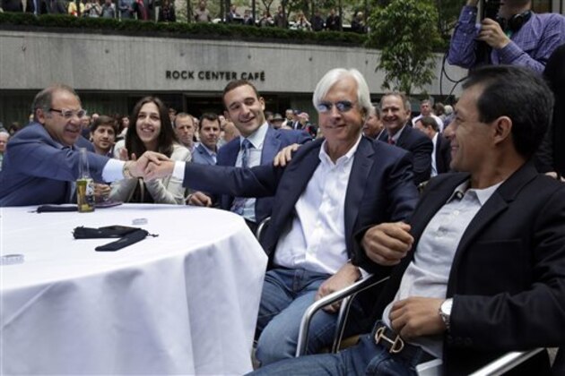 American Pharoah owner Ahmed Zayat, left, and his son Justin Zayat, congratulate, third from left, trainer Bob Baffert, second from right, and jockey Victor Espinoza, right, during the post position draw for the 147th Belmont Stakes at New York's Rockefeller Center, Wednesday, June 3, 2015. American Pharoah, who drew the No. 5 post position, was made the early 3-5 favorite on Wednesday to win the Belmont Stakes and become U.S. horse racing's first Triple Crown winner in 37 years. (AP Photo/Richard Drew)