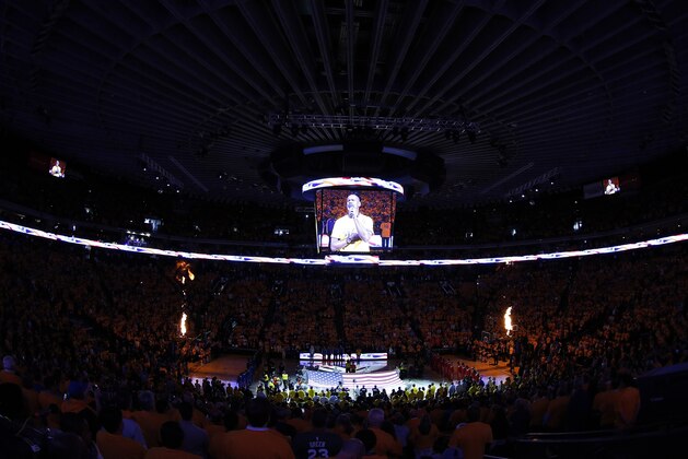 A flag is presented at Oracle Arena during the national anthem before Game 5 of the NBA basketball Western Conference finals between the Golden State Warriors and the Houston Rockets in Oakland, Calif., Wednesday, May 27, 2015. (AP Photo/Tony Avelar)