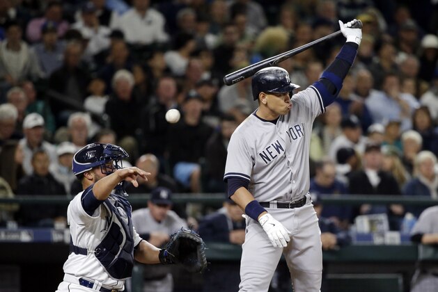 Seattle Mariners catcher Welington Castillo, left, tosses back a ball as New York Yankees' Alex Rodriguez is up to bat in a baseball game Tuesday, June 2, 2015, in Seattle. (AP Photo/Elaine Thompson)
