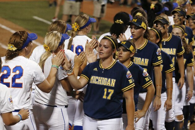 Michigan pitcher Haylie Wagner (17) leads her team as they high five Florida players, left, after Florida defeated Michigan 4-1in  the final game in the NCAA softball Women's College World Series, Wednesday, June 3, 2015, in Oklahoma City. (AP Photo/Sue Ogrocki)