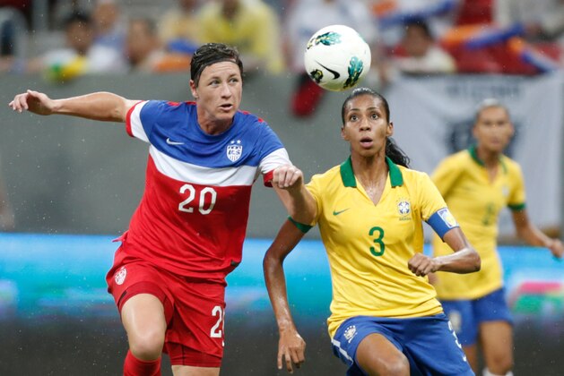 United States' Abby Wambach, left, fights for the ball with Brazil’s Bruna Benites, right, during a final match of the International Women's Football Tournament at the National Stadium in Brasilia, Brazil, Sunday, Dec. 21, 2014. (AP Photo/Eraldo Peres)