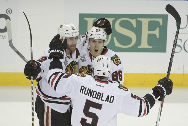 Chicago Blackhawks left wing Teuvo Teravainen (86) of Finland, top right, celebrates his goal with Duncan Keith (2) of Canada, left, and David Rundblad (5) of Sweden, during the third period in Game 1 of the NHL hockey Stanley Cup Final against the Tampa Bay Lightning in Tampa, Fla., Wednesday, June 3, 2015.  The Blackhawks won 2-1. (AP Photo/Phelan M. Ebenhack)
