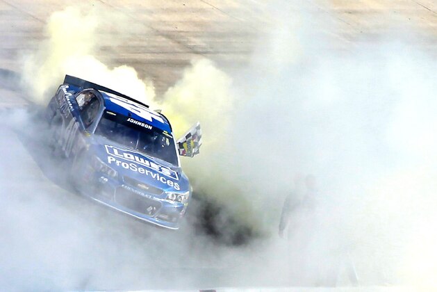DOVER, DE - MAY 31:  Jimmie Johnson, driver of the #48 Lowe's Pro Services Chevrolet, celebrates with a burnout after winning the NASCAR Sprint Cup Series FedEx 400 Benefiting Autism Speaks at Dover International Speedway on May 31, 2015 in Dover, Delaware.  (Photo by Brian Lawdermilk/Getty Images)
