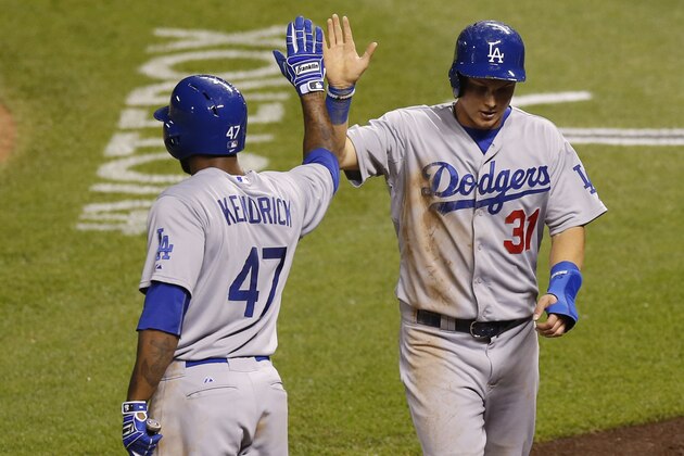 Los Angeles Dodgers' Howie Kendrick, left, congratulates Joc Pederson after he scored on a double by Justin Turner against the Colorado Rockies in the fifth inning of a baseball game Wednesday, June 3, 2015, in Denver. (AP Photo/David Zalubowski)