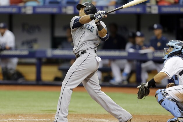 Seattle Mariners' Nelson Cruz follows the flight of his three-run home run off Tampa Bay Rays relief pitcher Brad Boxberger during the ninth inning of a baseball game Wednesday, May 27, 2015, in St. Petersburg, Fla.  Catching for the Rays is Rene Rivera. (AP Photo/Chris O'Meara)