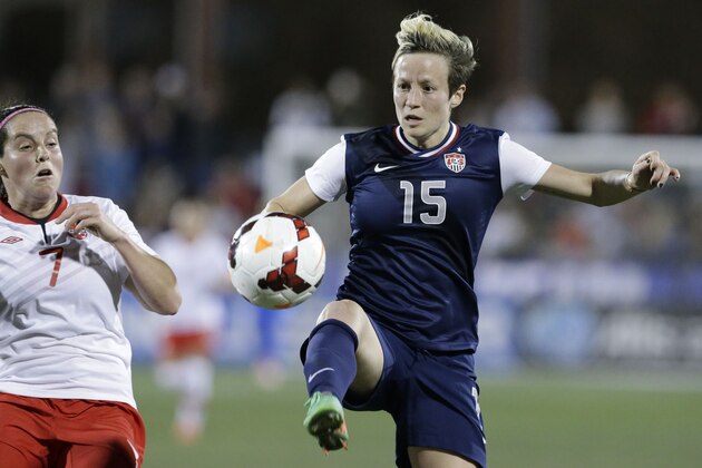 USA midfielder Megan Rapinoe (15) takes control of the ball against Canada defender Rhian Wilkinson (7) during the first half of a soccer game Friday, Jan. 31, 2014, in Frisco, Texas. (AP Photo/LM Otero)