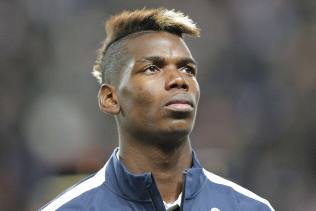 France's Paul Pogba, stands at attention during the Albanian National anthem prior to the start of a friendly soccer match France against Albania at Route de Lorient stadium in Rennes, western France, Friday, Nov. 14, 2014. The match ended in a 1-1 draw. (AP Photo/Michel Euler)