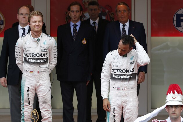 Mercedes driver Nico Rosberg of Germany, left, flanked by his teammate Lewis Hamilton of Britain, third placed, celebrates on the podium after winning the Formula One Grand Prix, at the Monaco racetrack, in Monaco, Sunday, May 24, 2015. (AP Photo/Luca Bruno)