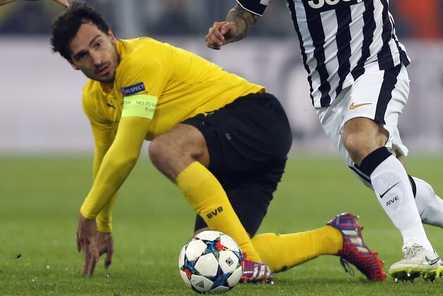 Juventus' Carlos Tevez, right, is challenged by Dortmund's Mats Hummels during the Champions League round of 16 second leg soccer match between Borussia Dortmund and Juventus Turin on Wednesday, March 18, 2015 in Dortmund, Germany. (AP Photo/Frank Augstein)