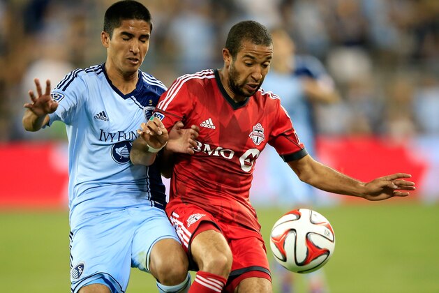 KANSAS CITY, KS - MAY 23:  Igor Juliao #40 of Sporting KC and Luke Moore #27 of Toronto FC battle for the ball during the game at Sporting Park on May 23, 2014 in Kansas City, Kansas.  (Photo by Jamie Squire/Getty Images)