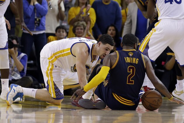 Cleveland Cavaliers guard Kyrie Irving (2) tries to control the ball next to Golden State Warriors guard Klay Thompson during overtime of Game 1 of basketball's NBA Finals in Oakland, Calif., Thursday, June 4, 2015. Irving left the game with an injury right after this play. (AP Photo/Ben Margot)