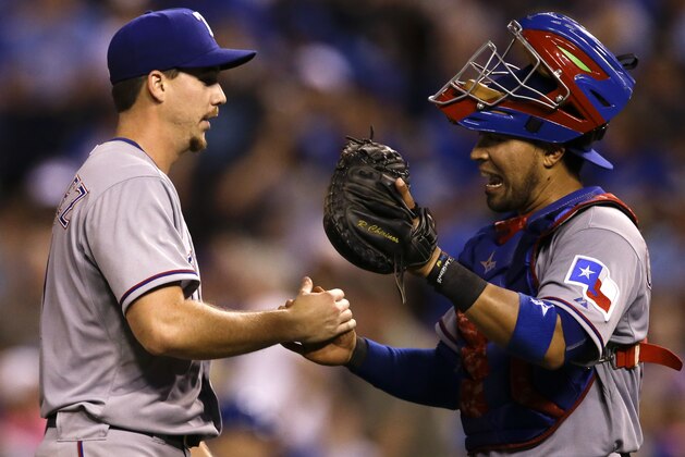 Texas Rangers starting pitcher Chi Chi Gonzalez, left, is congratulated by catcher Robinson Chirinos, right, following a baseball game against the Kansas City Royals at Kauffman Stadium in Kansas City, Mo., Friday, June 5, 2015. Gonzalez pitched a complete-game shutout of the Royals. The Rangers defeated the Royals 4-0. (AP Photo/Orlin Wagner)