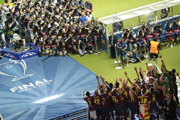 Barcelona players celebrate with the trophy after the Champions League final soccer match between Juventus Turin and FC Barcelona at the Olympic stadium in Berlin Saturday, June 6, 2015. Barcelona won the match 3-1. (AP Photo/Michael Sohn)