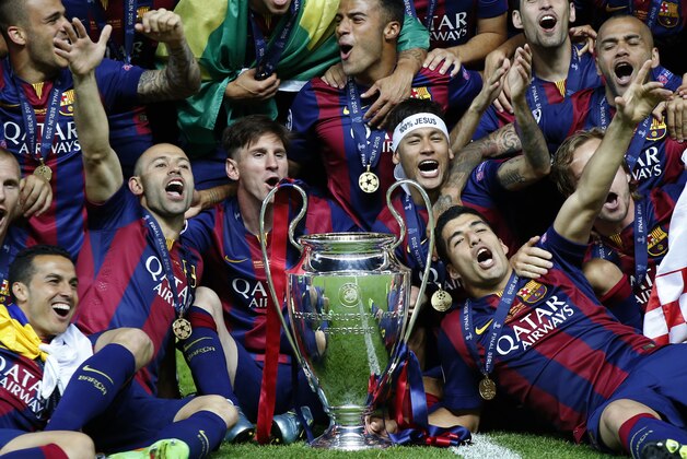 Barcelona players celebrate with the trophy after the Champions League final soccer match between Juventus Turin and FC Barcelona at the Olympic stadium in Berlin Saturday, June 6, 2015. Barcelona won the match 3-1. (AP Photo/Luca Bruno)