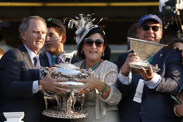 American Pharoah owner Ahmed Zayat, right, holds the Triple Crown trophy as his wife Joanne, center, and New York Racing Association CEO and President Christopher Kay hold the August Belmont trophy, after American Pharoah won the 147th running of the Belmont Stakes horse race at Belmont Park, Saturday, June 6, 2015, in Elmont, N.Y. American Pharoah is the first horse to win the Triple Crown since Affirmed won it in 1978.(AP Photo/Kathy Willens)