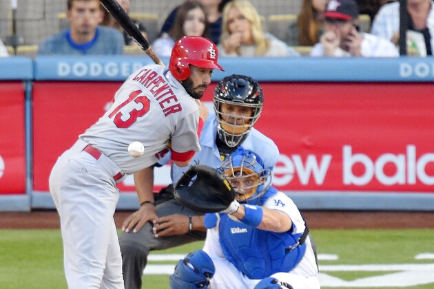 St. Louis Cardinals' Matt Carpenter, left, is hit by a pitch as Los Angeles Dodgers catcher A.J. Ellis, lower right, and home plate umpire CB Bucknor watch during the first inning of a baseball game, Saturday, June 6, 2015, in Los Angeles. (AP Photo/Mark J. Terrill)