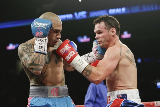 Miguel Cotto, left, of Puerto Rico, punches Daniel Geale, of Australia, during the first round of a boxing match Saturday, June 6, 2015, in New York. (AP Photo/Frank Franklin II)