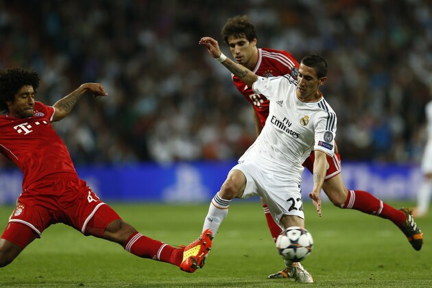 Bayern's Dante fights for the ball with Real's Angel Di Maria during a first leg semifinal Champions League soccer match between Real Madrid and Bayern Munich at the Santiago Bernabeu stadium in Madrid, Spain, Wednesday, April 23, 2014. (AP Photo/Andres Kudacki)