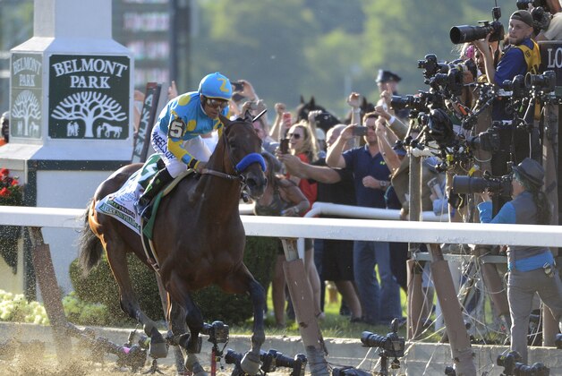 Jockey Victor Espinoza eases up American Pharoah (5) after crossing the finish line to win the 147th running of the Belmont Stakes horse race at Belmont Park, Saturday, June 6, 2015, in Elmont, N.Y. American Pharoah is the first horse to win the Triple Crown since Affirmed won it in 1978.  (AP Photo/Bill Kostroun)