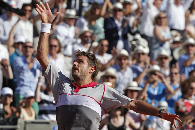Switzerland's Stan Wawrinka throws his racket in the air as he celebrates winning the men's final of the French Open tennis tournament in four sets, 4-6, 6-4, 6-3, 6-4, against Serbia's Novak Djokovic at the Roland Garros stadium, in Paris, France, Sunday, June 7, 2015. (AP Photo/Michel Euler)