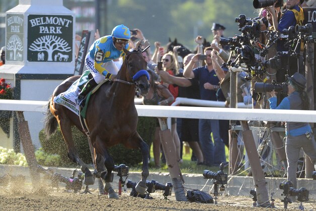 Jockey Victor Espinoza eases up American Pharoah (5) after crossing the finish line to win the 147th running of the Belmont Stakes horse race at Belmont Park, Saturday, June 6, 2015, in Elmont, N.Y. American Pharoah is the first horse to win the Triple Crown since Affirmed won it in 1978.  (AP Photo/Bill Kostroun)