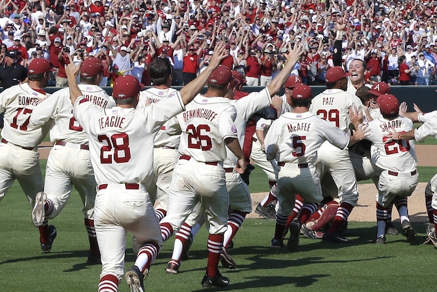 Arkansas pitcher Zach Jackson, right, is swarmed by teammates as he holds up one finger after a super regional of the NCAA college baseball tournament in Fayetteville, Ark., Sunday, June 7, 2015. Arkansas defeated Missouri State 3-2. (AP Photo/Danny Johnston)