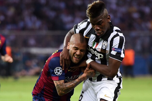 BERLIN, GERMANY - JUNE 06:  Daniel Alves of Barcelona challenges for the ball with Paul Pogba of Juventus during the UEFA Champions League Final between Juventus and FC Barcelona at Olympiastadion on June 6, 2015 in Berlin, Germany.  (Photo by Matthias Hangst/Getty Images)
