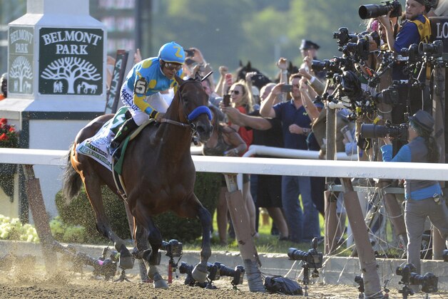 Jockey Victor Espinoza eases up American Pharoah (5) after crossing the finish line to win the 147th running of the Belmont Stakes horse race at Belmont Park, Saturday, June 6, 2015, in Elmont, N.Y. American Pharoah is the first horse to win the Triple Crown since Affirmed won it in 1978.  (AP Photo/Bill Kostroun)