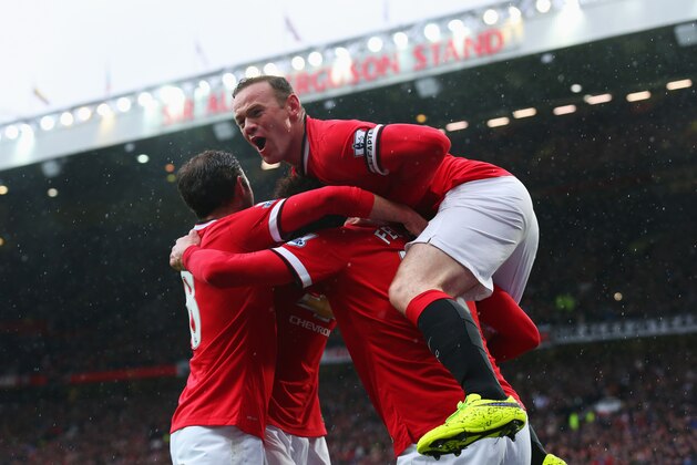 MANCHESTER, ENGLAND - APRIL 12:  Marouane Fellaini of Manchester United (2R) is congratulated by captain Wayne Rooney (R) and team mates as he scores their second goal with a header during the Barclays Premier League match between Manchester United and Manchester City at Old Trafford on April 12, 2015 in Manchester, England.  (Photo by Alex Livesey/Getty Images)