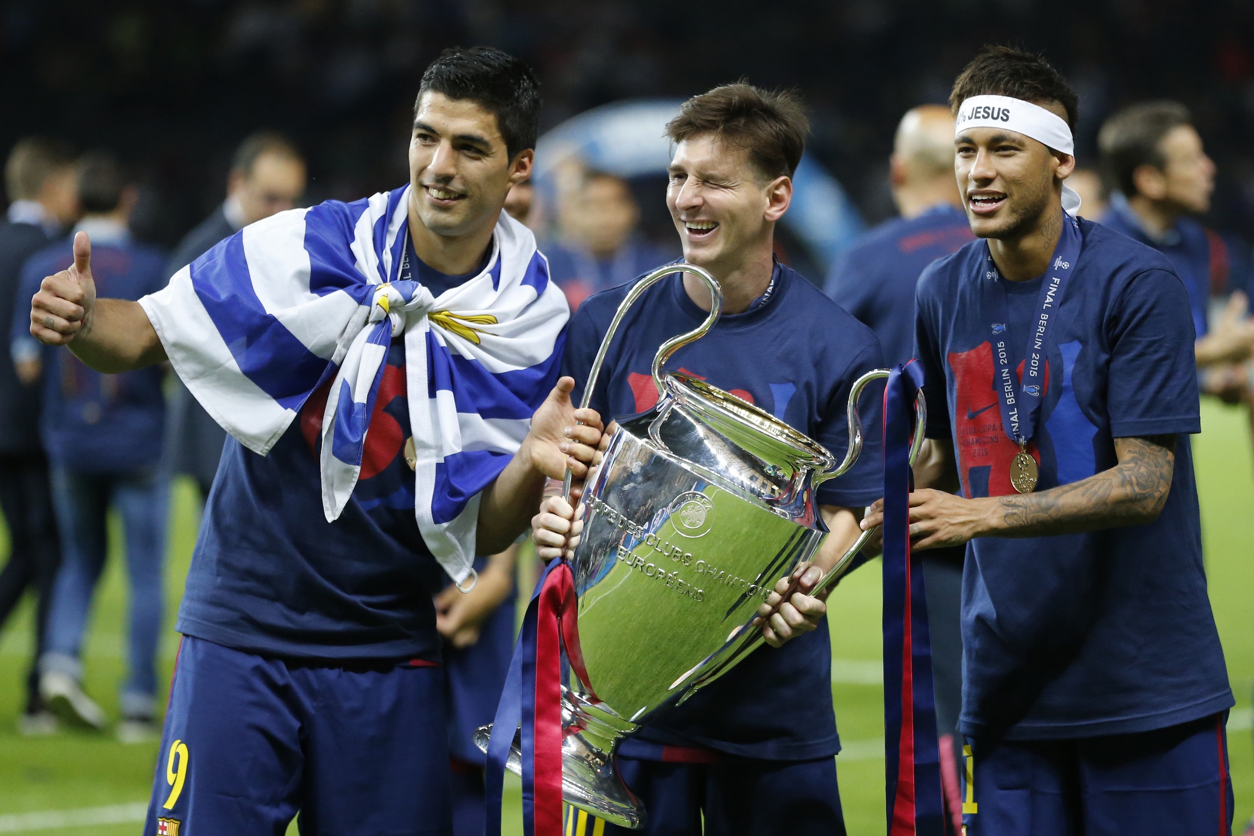 Barcelona's Lionel Messi, centre, Neymar and Luis Suarez, left, celebrate with the trophy after after the Champions League final soccer match between Juventus Turin and FC Barcelona at the Olympic stadium in Berlin Saturday, June 6, 2015. Barcelona won the match 3-1.  (AP Photo/Frank Augstein)