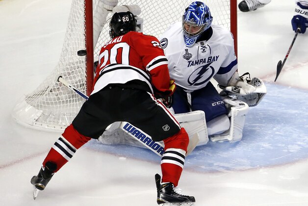 Chicago Blackhawks' Brandon Saad, right, shoots wide of Tampa Bay Lightning goalie Ben Bishop during the third period in Game 3 of the NHL hockey Stanley Cup Final on Monday, June 8, 2015, in Chicago. (AP Photo/Charles Rex Arbogast)