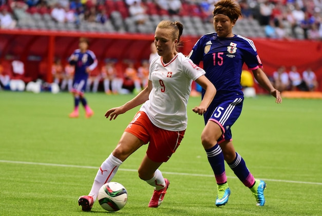Jun 8, 2015; Vancouver, British Columbia, CAN; Switzerland midfielder Lia Waelti (9) kicks the ball in front of Japan forward Yuika Sugasawa (15) during the second half in a Group C soccer match in the 2015 women's World Cup at BC Place Stadium. Mandatory Credit: Anne-Marie Sorvin-USA TODAY Sports