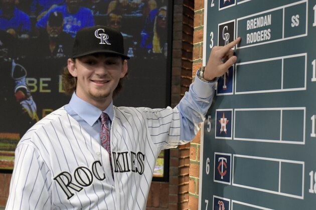 Shortstop Brendan Rodgers from Lake Mary High School in Longwood, Fla., points to his name on the board after being selected by the Colorado Rockies with the third selection at the 2015 MLB baseball draft Monday, June 8, 2015, in Secaucus, N.J.  (AP Photo/Bill Kostroun)