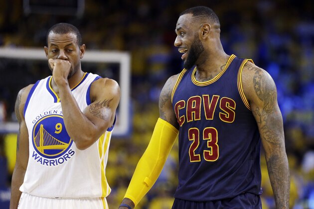Cleveland Cavaliers forward LeBron James (23) smiles next to Golden State Warriors forward Andre Iguodala (9) during the second half of Game 2 of basketball's NBA Finals in Oakland, Calif., Sunday, June 7, 2015. (AP Photo/Ben Margot)