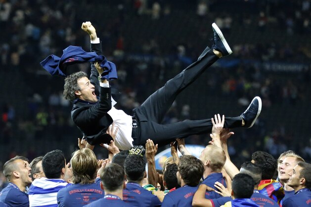 Barcelona's head coach Luis Enrique is thrown into the air by his players after the Champions League final soccer match between Juventus Turin and FC Barcelona at the Olympic stadium in Berlin Saturday, June 6, 2015. Barcelona won the match 3-1.  (AP Photo/Frank Augstein)