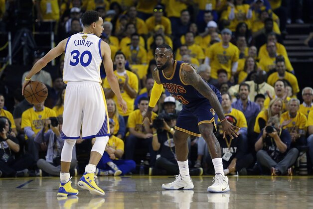 Cleveland Cavaliers forward LeBron James, right, guards Golden State Warriors guard Stephen Curry (30) during the first half of Game 1 of basketball's NBA Finals in Oakland, Calif., Thursday, June 4, 2015. (AP Photo/Ben Margot)