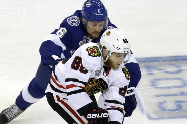Tampa Bay Lightning defenseman Anton Stralman, back, battles Chicago Blackhawks right wing Patrick Kane for the puck with during the first period in Game 2 of the NHL hockey Stanley Cup Final on Saturday, June 6, 2015, in Tampa Fla. (AP Photo/John Raoux)