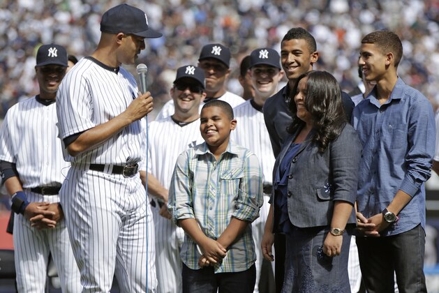 FILE - In this Sept. 22, 2013 file photo, New York Yankees relief pitcher Mariano Rivera, holding microphone, thanks his family including his sons Jaziel, laughing, Mariano Jr., second from right, rear, and Jafet, far right, and his wife Clara, second from right, foreground, during a retirement ceremony at Yankee Stadium before the Yankees baseball game against the San Francisco Giants, in New York. Mariano Rivera Jr. will join the Laconia Muskrats this summer, part of the 12-team New England Collegiate Baseball League. He's a right-hander, like his dad. (AP Photo/Kathy Willens, File)