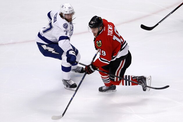 Chicago Blackhawks' Jonathan Toews, right, handles the puck as Tampa Bay Lightning's Victor Hedman, of Sweden, defends during the first period in Game 3 of the NHL hockey Stanley Cup Final on Monday, June 8, 2015, in Chicago. (AP Photo/Charles Rex Arbogast)