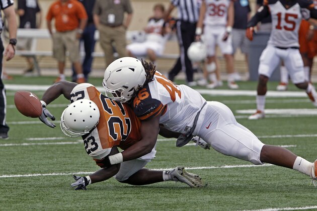 Texas running back Daje Johnson (23) fumbles the ball when tackled by linebacker Malik Jefferson (46) during the second quarter of Texas' Orange and White spring NCAA college football game, Saturday, April 18, 2015, in Austin, Texas. (AP Photo/Michael Thomas)