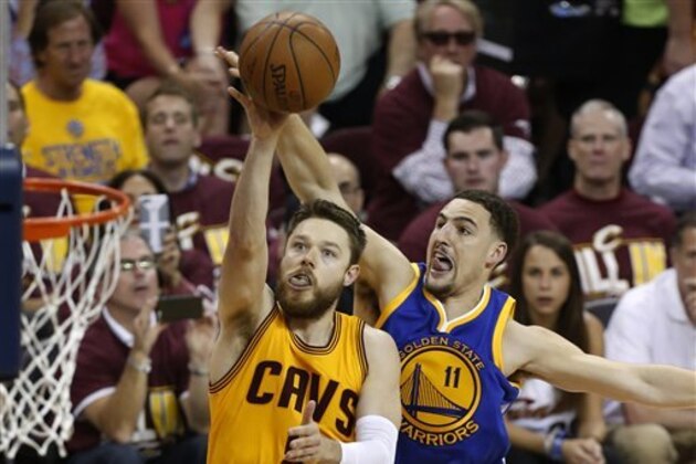 Cleveland Cavaliers guard Matthew Dellavedova (8) shoots in front of Golden State Warriors guard Klay Thompson (11) during the second half of Game 3 of basketball's NBA Finals in Cleveland, Tuesday, June 9, 2015. (AP Photo/Paul Sancya)